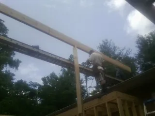 Carpenter setting a ridge beam over a new addition frame — Ice Dam Removal by Roofing Brothers in Lydia