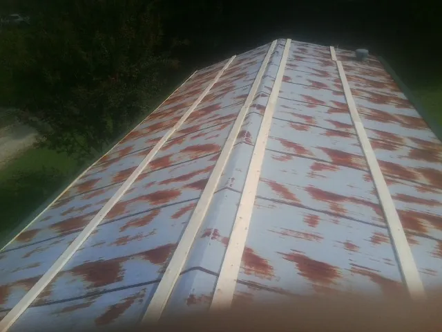 Rusted metal roof panels with new wood purlins before replacement — Storm Damage Roof Repair in Lydia by Roofing Brothers