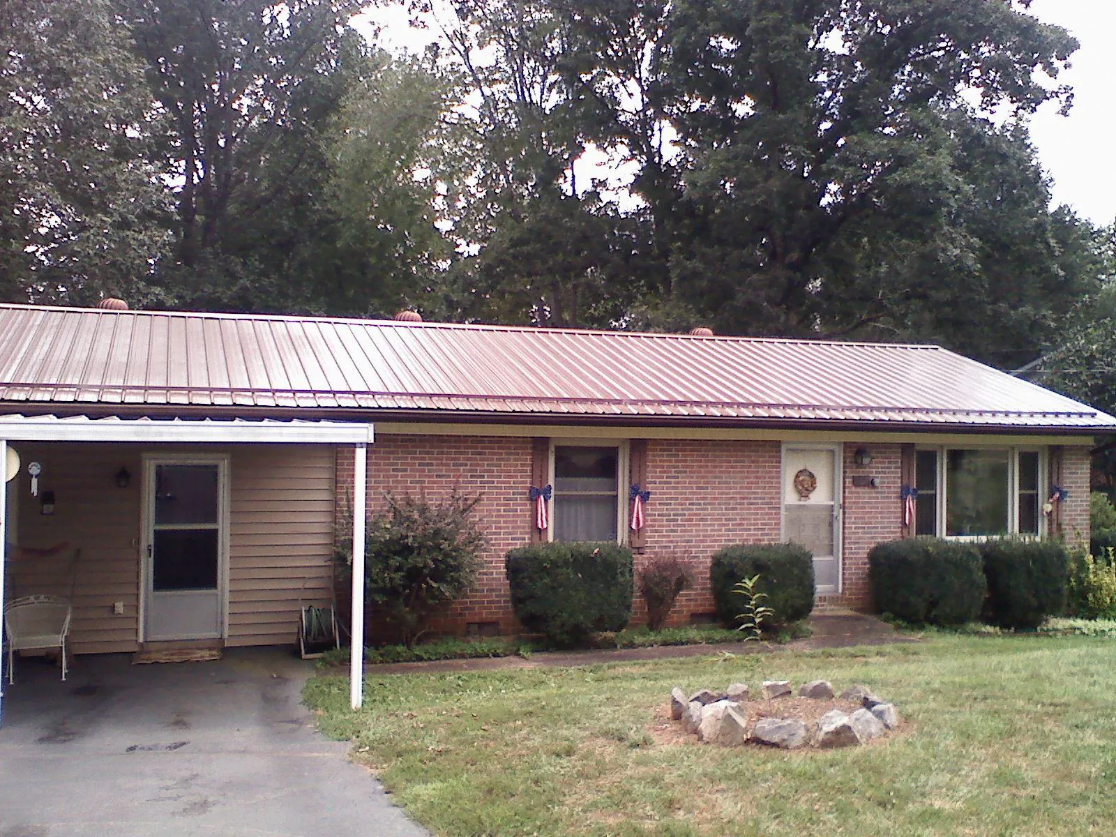 Bronze metal roof and carport on a brick ranch home — Roof Repair work by our crew in Lydia